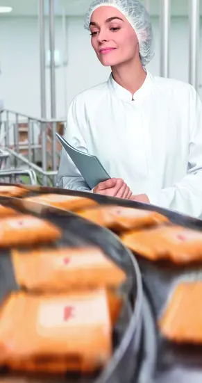 Bild einer Frau an einem Fließband in der Lebensmittelproduktion