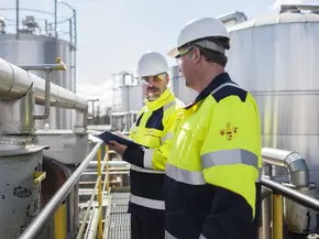 Bild von zwei Arbeitern in Schutzausrüstung
