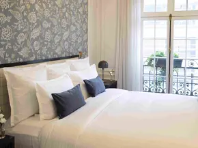 Bild eines gemachten Hotelbettes mit grauen Kissen