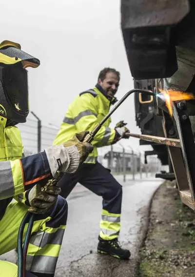 Bild von 2 Menschen, schweißend an einer Eisenbahn mit PSA
