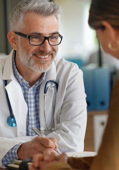 Bild eines lächelnden Arztes im Gespräch mit einer Patientin