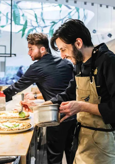 Bild zweier Köche in Elis Berufsbekleidung mit Spaß bei der Arbeit