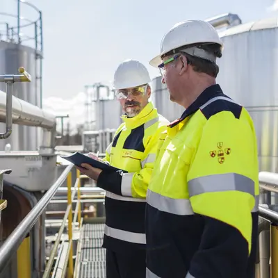 Bild von zwei Arbeitern in Schutzausrüstung